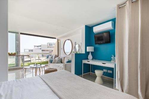 een slaapkamer met een bed en een blauwe muur bij Blue Coral Heliopolis Naturiste in Cap d'Agde