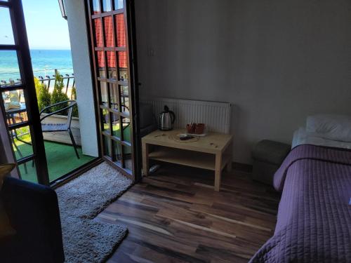 a bedroom with a bed and a table with a view of the ocean at Dom Przy Plaży in Sarbinowo
