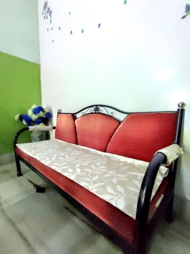 a red couch in the corner of a room at Peaceful Living in Kolkata