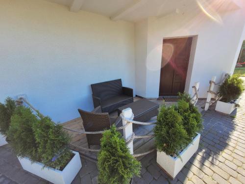 a patio with potted plants and a couch in front of a building at Dom Przy Plaży in Sarbinowo