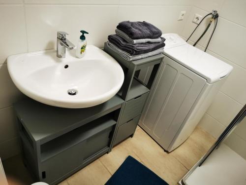 W łazience znajduje się biała umywalka oraz blat ze zlewem. w obiekcie Zentrale, ruhige Wohnung nahe Murinsel & Kunsthaus w Grazu