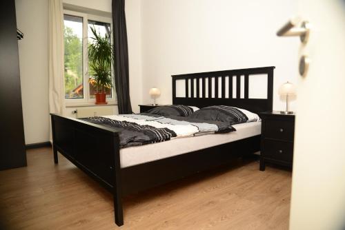 a bedroom with a black bed with a window at Ferienanlage Markus Nitsch in Bärenstein
