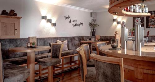a restaurant with tables and chairs and a bar at Appartements KATHRIN in Grossarl