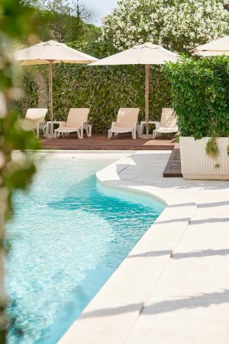 a swimming pool with chairs and umbrellas at Hotel Admiral in Budva