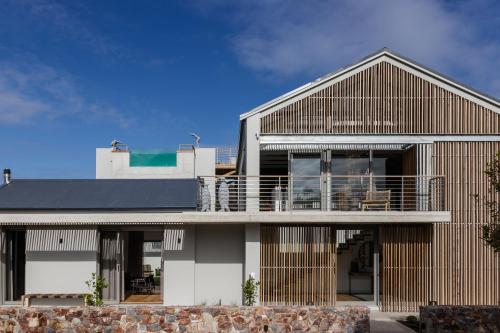 a modern house with a wooden facade at White Pearl in Hermanus