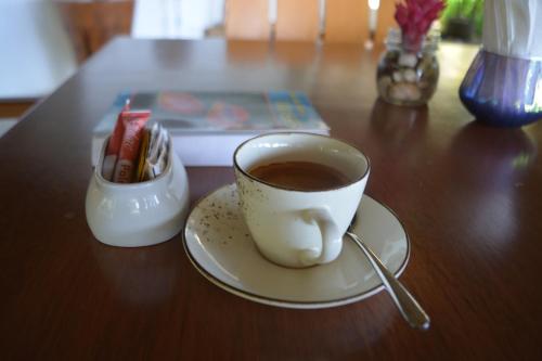 a cup of coffee sitting on a wooden table at Murex Dive Resort in Manado