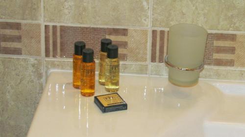 three bottles of essential oils sitting on a bath tub at St Ivan Rilski Spa Luxury apartment Bansko & Free SPA in Bansko