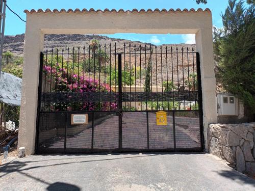 a gate with a bunch of flowers behind it at Time To Experience in Salobre