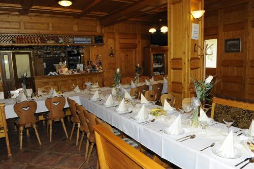 a dining room with a long table with white table cloth at Penzion Diana in Teplice nad Bečvou