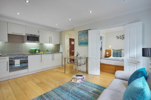 a kitchen and living room with a couch and a table at Nell Gwynn Chelsea Accommodation in London