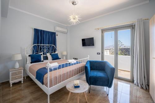 Loulaki villas santorini في Vourvoúlos: غرفة نوم بسرير وكرسي ازرق