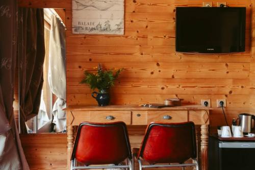 two red chairs in a room with a television at Les Grands Montets Hotel & Spa in Chamonix