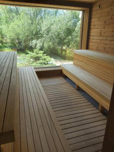 a sauna with wooden benches and a large window at St Ivan Rilski Spa Luxury apartment Bansko & Free SPA in Bansko