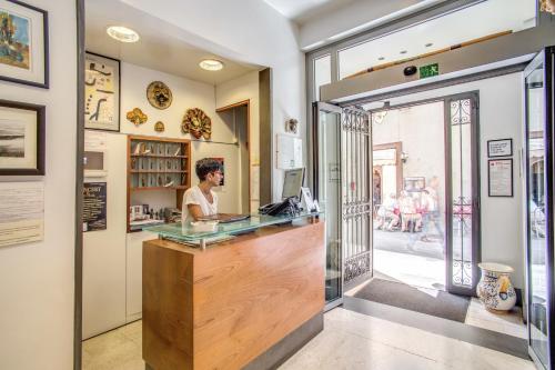 a woman standing at the counter of a restaurant at Hotel Nuova Italia in Florence