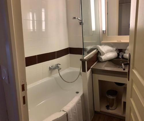 a bathroom with a bath tub and a sink at Cap Esterel 2 pièces Climatisé 4-5pers Piscines Parking Draps Wifi in Saint-Raphaël