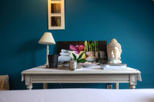 a table with a statue and other items on it at Tulip Inn Honfleur Residence & Spa in Honfleur