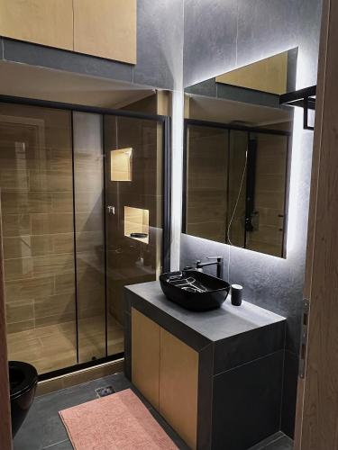 a bathroom with a black sink and a shower at SEA HORIZON SUITES in Chalkida