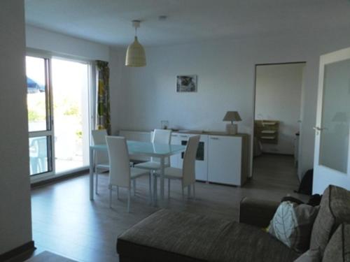 un salon avec une table et des chaises dans l'établissement Appartement 2 Pièces à La Rochelle avec Balcon, Proche Plage des Minimes et Port, Parking Inclus - FR-1-551-7, à La Rochelle
