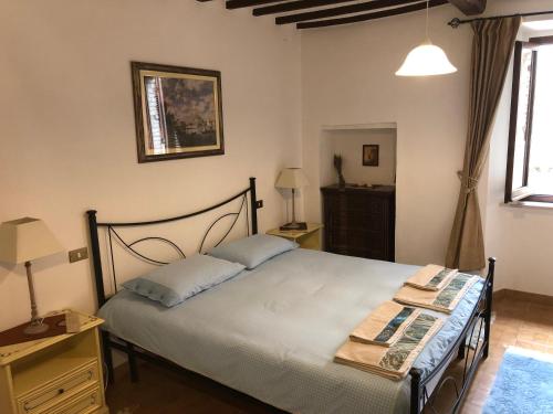 a bedroom with a bed and a table and a lamp at Casa in Umbria in Monte Castello di Vibio