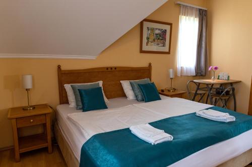 バラトンフレドにあるMagnólia Apartmanházのベッドルーム1室(ベッド1台、タオル2枚付)