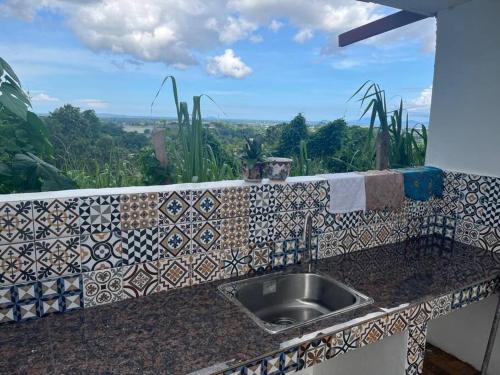 a kitchen counter with a sink with a tile back splash at Beautiful 3 bedroom vacation home with view. in Zamboanga