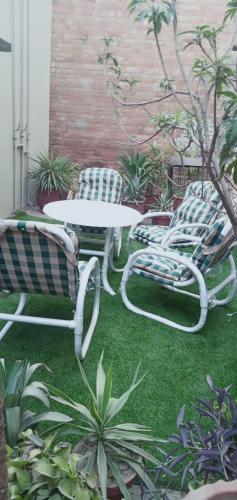 a patio with a table and chairs and plants at Family Guest House Lahore Near Airport in Lahore