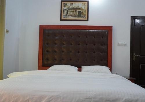 a bedroom with a large bed with a large headboard at Family Guest House Lahore Near Airport in Lahore