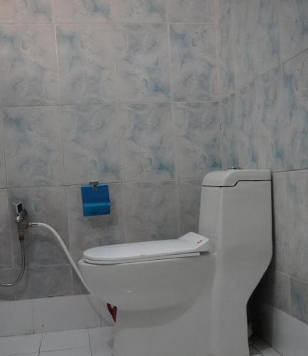 a bathroom with a toilet and a blue sign on the wall at Family Guest House Lahore Near Airport in Lahore