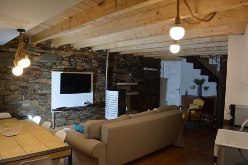 a living room with a couch and a stone wall at Casa do Azereiro in Casal do Rei