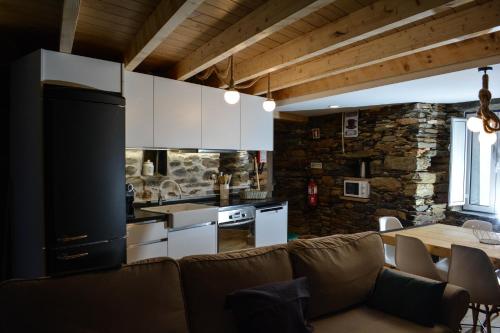 a living room with a couch and a kitchen at Casa do Azereiro in Casal do Rei