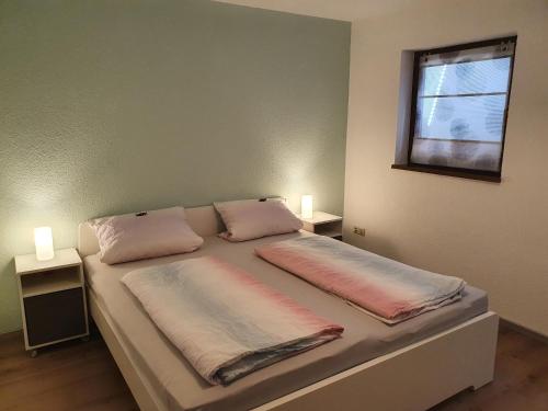 een slaapkamer met een bed met 2 kussens erop bij Haus am Eckle in Kleines Wiesental