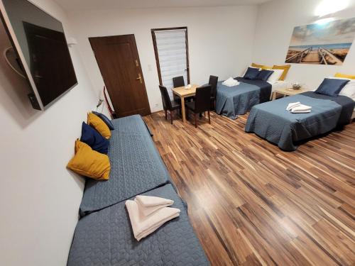 a hotel room with two beds and a television at Dom Przy Plaży in Sarbinowo