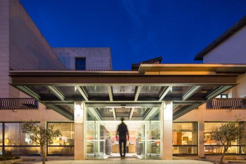 Un uomo che entra in un edificio di notte di Hotel Dom Goncalo & Spa a Fátima