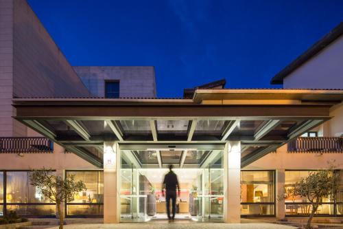 a man walking into a building at night at Hotel Dom Goncalo & Spa in Fátima