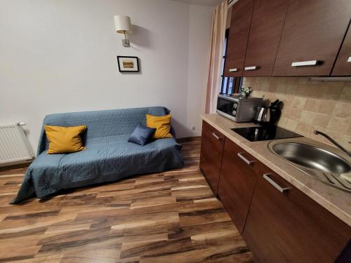 a small kitchen with a bed and a sink at Dom Przy Plaży in Sarbinowo