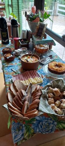 a table topped with lots of different types of food at Pousada Casa Mato in Taubaté