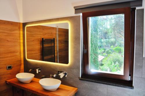 a bathroom with two sinks and a large window at Spettacolare vista isola Terrazza e idromassaggio in Noli