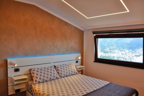 1 dormitorio con cama y ventana en Spettacolare vista isola Terrazza e idromassaggio en Noli