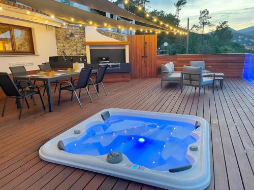 a jacuzzi tub sitting on a wooden deck at Spettacolare vista isola Terrazza e idromassaggio in Noli