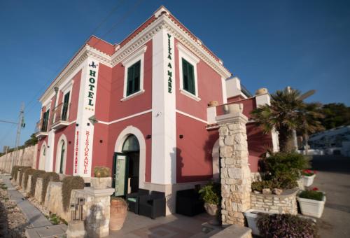 a red and white building on a street at Hotel Villa A Mare in Rodi Garganico
