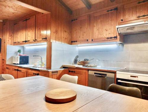 une cuisine avec des armoires en bois et une table en bois dans l'établissement La Clusaz Ski aux pieds, à La Clusaz