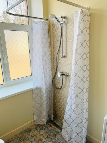 a shower with a shower curtain in a bathroom at Maria Apartment Roomassaare in Kuressaare