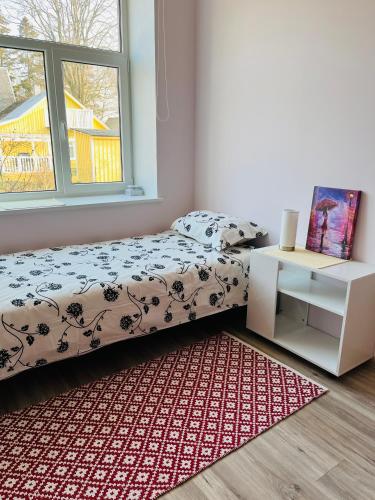 a bedroom with a bed and a table and a rug at Maria Apartment Roomassaare in Kuressaare