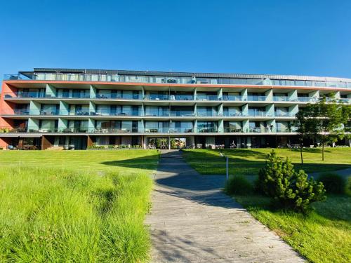 a large building with a path in front of it at BL LAKESIDE APARTMAN in Balatonlelle