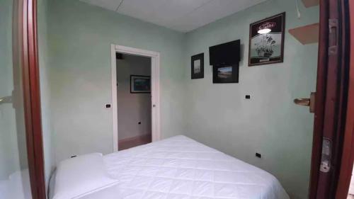 een slaapkamer met een wit bed en een spiegel bij SPERLONGA VILLETTA SUL MARE CON ACCESSO ALLE SPIAGGIA POSIZIONE ESCLUSIVA in Sperlonga