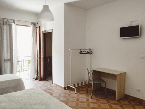 1 dormitorio con escritorio, 1 cama y ventana en Dimora degli Enotri en Scalea