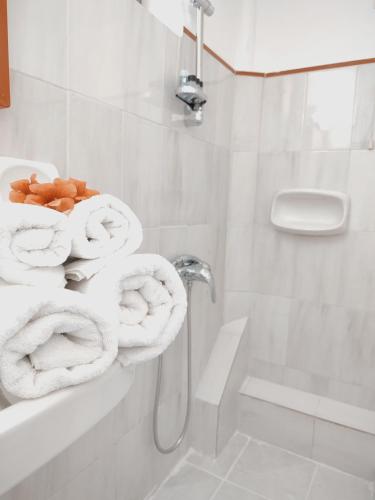 a white bathroom with towels on a wall at Lefka Ori - Agia Galini in Agia Galini