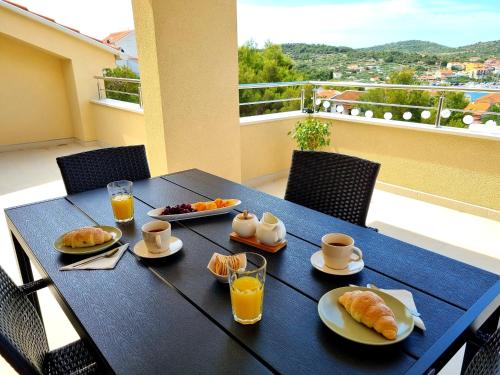 a black table with breakfast food on a balcony at Apartment Leona in Jezera
