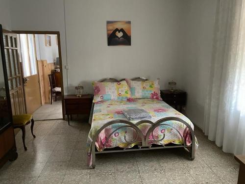 una camera da letto con un letto con un piumone colorato di Casa en arisgotas con encanto a Arisgotas