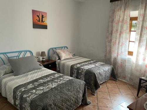 a bedroom with two beds and a window at Casa en arisgotas con encanto in Arisgotas